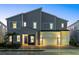 Modern two-story house with gray siding, two-car garage, and nighttime lighting at 1735 Oak Blossom Dr, Davenport, FL 33837