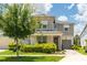 Two story house with light beige siding and dark roof at 8963 Amelia Downs Trl, Kissimmee, FL 34747