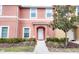 Two-story townhome with peach-colored exterior, walkway, and landscaping at 3006 Red Ginger Rd, Kissimmee, FL 34747