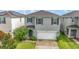 Two-story house with gray siding, white garage door, and landscaping at 6728 Huntleigh Hammock Rd, Harmony, FL 34773
