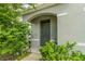 Dark green front door with arched entryway and lush landscaping at 6728 Huntleigh Hammock Rd, Harmony, FL 34773