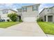 Two-story house with gray siding, white garage door, and landscaping at 6728 Huntleigh Hammock Rd, Harmony, FL 34773