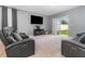 Living room with reclining sofas, TV, and sliding glass door to backyard at 6728 Huntleigh Hammock Rd, Harmony, FL 34773