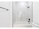 Simple bathroom with a bathtub, marble tile, and white fixtures at 1306 Congo Dr, Poinciana, FL 34759