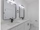 Modern bathroom with double vanity, black matte fixtures, and white cabinets at 1306 Congo Dr, Poinciana, FL 34759