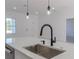 Modern kitchen island with quartz countertop and black faucet at 1306 Congo Dr, Poinciana, FL 34759