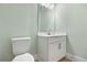 Small powder room with white vanity and a light green wall at 15424 Enchanted Melody Way, Winter Garden, FL 34787