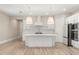 Modern white kitchen with island, stainless steel appliances, and light wood floors at 15424 Enchanted Melody Way, Winter Garden, FL 34787