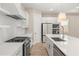 Modern white kitchen with island, stainless steel appliances, and light wood floors at 15424 Enchanted Melody Way, Winter Garden, FL 34787