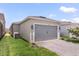 Gray garage door with paver driveway and landscaping at 15424 Enchanted Melody Way, Winter Garden, FL 34787
