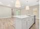 Modern white kitchen island with sink and stainless steel appliances at 15424 Enchanted Melody Way, Winter Garden, FL 34787
