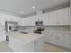 Modern kitchen featuring white cabinets, stainless steel appliances, and an island at 2035 Stetson Ct, Eagle Lake, FL 33839