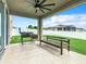 Covered patio with ceiling fan, grill, and bench overlooking backyard at 592 Lake Smart Blvd, Winter Haven, FL 33881