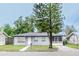 Ranch-style house with gray exterior and a large tree at 225 E Pomelo St, Lake Alfred, FL 33850