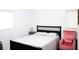 Comfortable bedroom with a queen-size bed and a pink armchair at 225 E Pomelo St, Lake Alfred, FL 33850