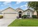 Tan one-story house with a two-car garage and landscaped yard at 170 Thornbury Dr, Kissimmee, FL 34744