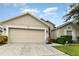 Tan one-story house with a two-car garage and landscaped front yard at 170 Thornbury Dr, Kissimmee, FL 34744