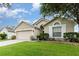 Tan one-story house with a two-car garage and well-manicured lawn at 170 Thornbury Dr, Kissimmee, FL 34744