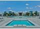 Community pool and spa with ample lounge chairs and umbrellas at 7760 Sandy Ridge Dr # 214, Kissimmee, FL 34747