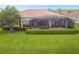 House back view showing a large screened patio and well manicured lawn at 154 Rancho Mirage Dr, Kissimmee, FL 34759
