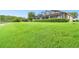 Large backyard with lush green grass leading to a pond at 154 Rancho Mirage Dr, Kissimmee, FL 34759