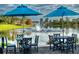 Patio seating area with blue umbrellas overlooking a fountain and lake at 154 Rancho Mirage Dr, Kissimmee, FL 34759