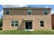 Two-story house with tan siding, multiple windows, and a sliding glass door leading to a backyard at 108 Country Walk Cir, Davenport, FL 33837
