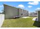 Large backyard with a two-story house, grassy area, and AC units at 5051 Plymouth Turtle Cir, St Cloud, FL 34772