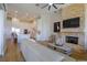 Open Gathering room with white sofa, stone fireplace, and kitchen access at 4962 Lazy Oaks Way, St Cloud, FL 34771