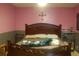 Bedroom with dark wood bed frame and pink walls at 267 Cranbrook Dr, Kissimmee, FL 34758