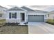 Curb appeal of a charming one-story house with gray siding and stone accents at 4244 Sawtooth Ct, Tavares, FL 32778