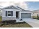 One-story home with gray siding, stone accents, and a two-car garage at 4244 Sawtooth Ct, Tavares, FL 32778