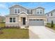 Two-story house with gray siding, stone accents, and a gray garage door at 4255 Sawtooth Ct, Tavares, FL 32778