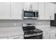 Stainless steel range and microwave above white cabinets at 4255 Sawtooth Ct, Tavares, FL 32778