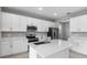 Modern kitchen with white cabinets, stainless steel appliances, and an island at 4255 Sawtooth Ct, Tavares, FL 32778