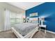 Bedroom with a queen-size bed, blue accent wall, and window at 880 Pebble Beach Dr, Davenport, FL 33896