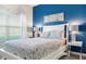 Bedroom with white bed frame, blue accent wall, and window at 880 Pebble Beach Dr, Davenport, FL 33896