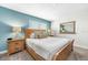 Primary bedroom with wood bed frame, nightstand, and mirror at 880 Pebble Beach Dr, Davenport, FL 33896