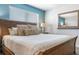 Primary bedroom with wood bed frame and blue accent wall at 880 Pebble Beach Dr, Davenport, FL 33896