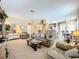 Bright and airy living room with comfy seating and a view into the kitchen at 1038 Orange Cosmos Blvd, Davenport, FL 33837