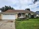 Brick house with a brown roof, white garage door, and landscaped lawn at 1949 Tiptree Cir, Orlando, FL 32837