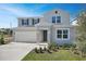 Two-story house with light beige siding, gray shutters, and a two-car garage at 308 Alexandrite St, Deland, FL 32720