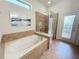 Bathroom with a garden tub, walk-in shower, and natural light at 1921 Nice Ct, Kissimmee, FL 34747