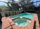 Relaxing screened-in pool and spa area with brick decking at 1921 Nice Ct, Kissimmee, FL 34747