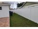 Backyard with grassy lawn and white vinyl fence at 2518 Bowmer Dr, Kissimmee, FL 34744