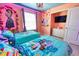 Two twin beds in a themed bedroom with a mural, accent lighting, and TV at 3725 Pacific Ln, Davenport, FL 33897