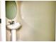 Small, simple powder room with pedestal sink and oval mirror at 3725 Pacific Ln, Davenport, FL 33897