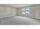 Bright bedroom with grey carpet and a large window at 1413 August Gray Dr, Kissimmee, FL 34744