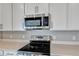 Modern kitchen with stainless steel appliances and white cabinets at 1413 August Gray Dr, Kissimmee, FL 34744