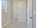 Bright laundry room with tile flooring and a white door at 1413 August Gray Dr, Kissimmee, FL 34744